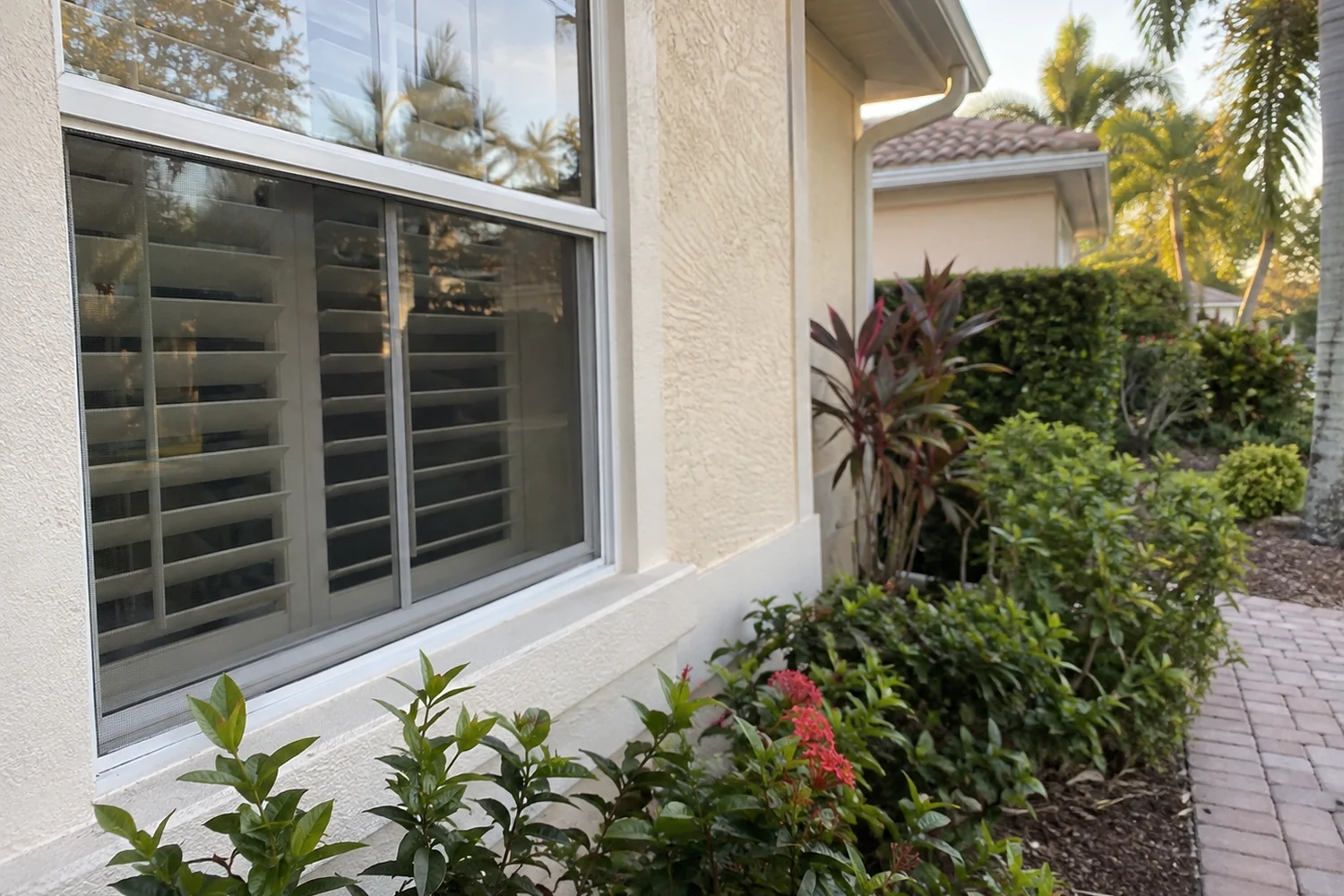 Bonita Springs home window and cream exterior beside courtyard planting